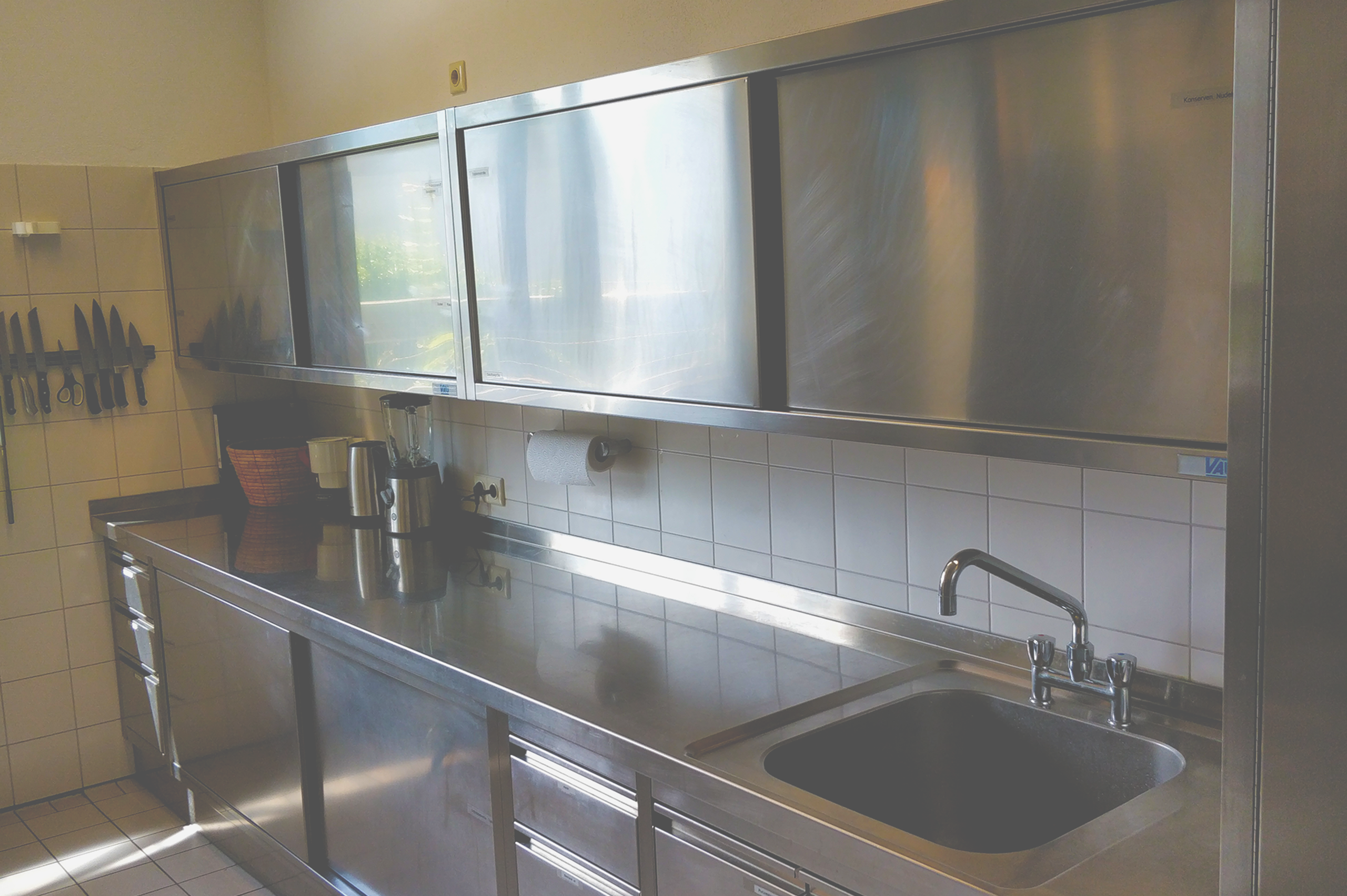 Foto von Küchenschränken aus Metall und einer Küchenspüle.